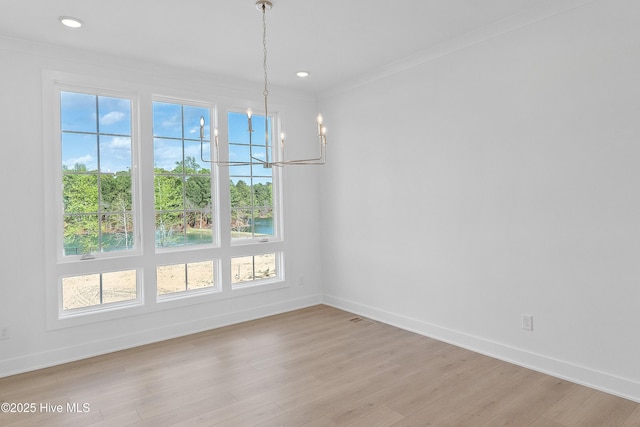 unfurnished dining area featuring baseboards, an inviting chandelier, recessed lighting, light wood-style flooring, and crown molding
