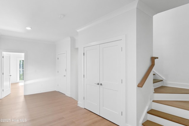 hall with baseboards, recessed lighting, crown molding, stairs, and light wood-style floors