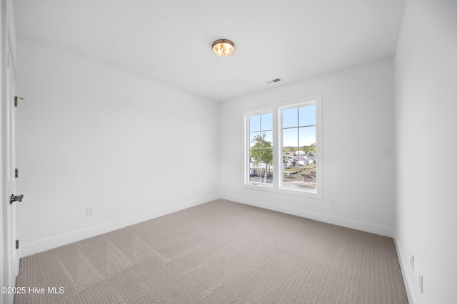 carpeted empty room featuring visible vents and baseboards