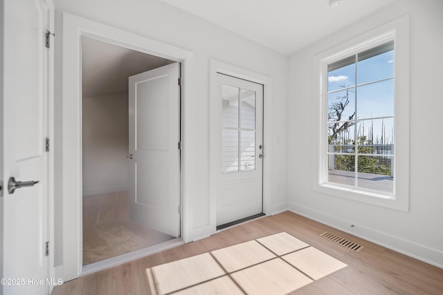 foyer featuring visible vents, light wood-type flooring, and baseboards