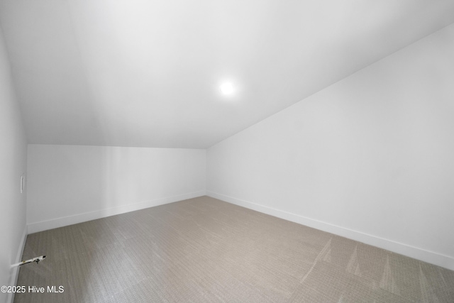 additional living space with baseboards and lofted ceiling
