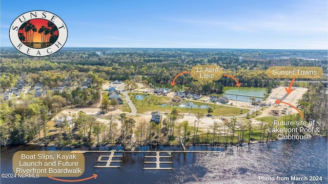 birds eye view of property featuring a forest view and a water view