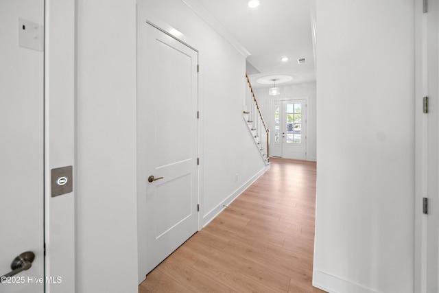 hall with light wood finished floors, recessed lighting, and stairway
