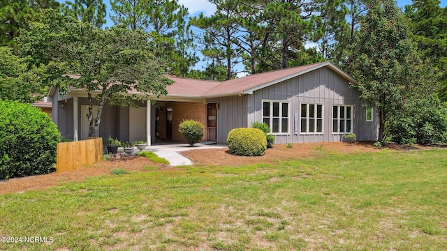 single story home featuring a front lawn