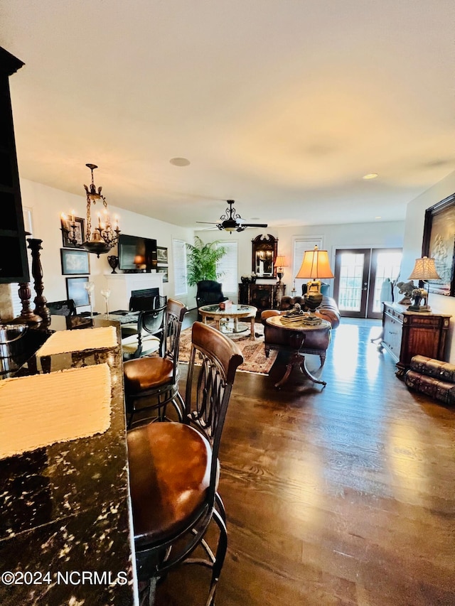 dining room with ceiling fan with notable chandelier and hardwood / wood-style floors