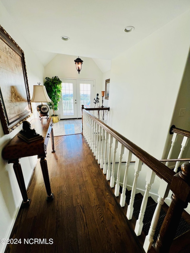 hall featuring wood-type flooring, vaulted ceiling, and french doors