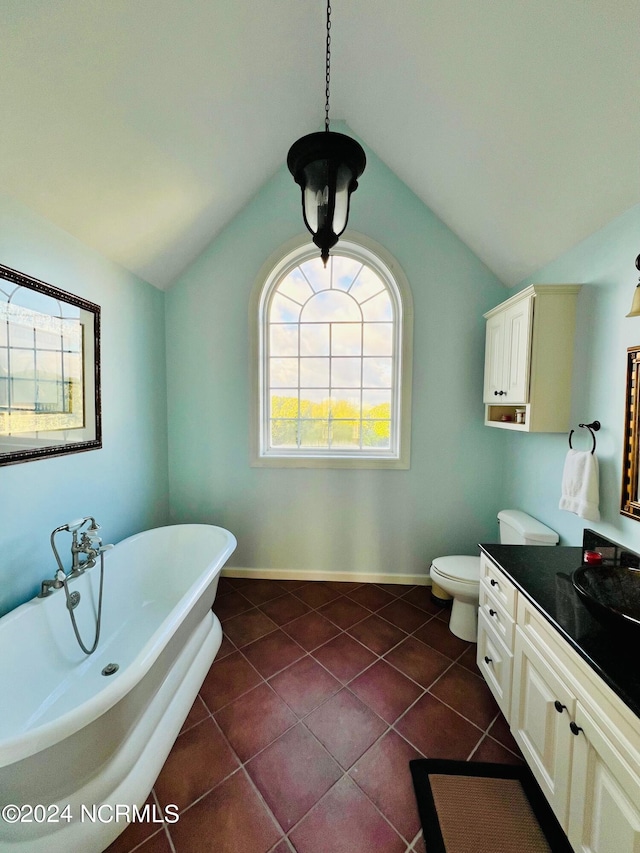 bathroom with lofted ceiling, toilet, vanity, and a bathing tub