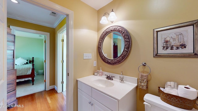 bathroom with vanity, toilet, and wood-type flooring