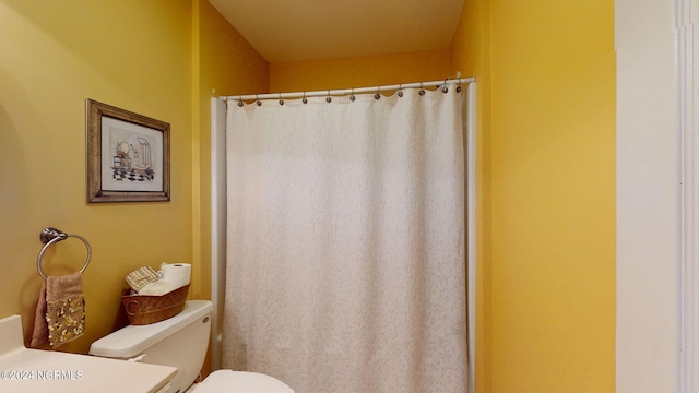 bathroom with curtained shower, toilet, and vanity