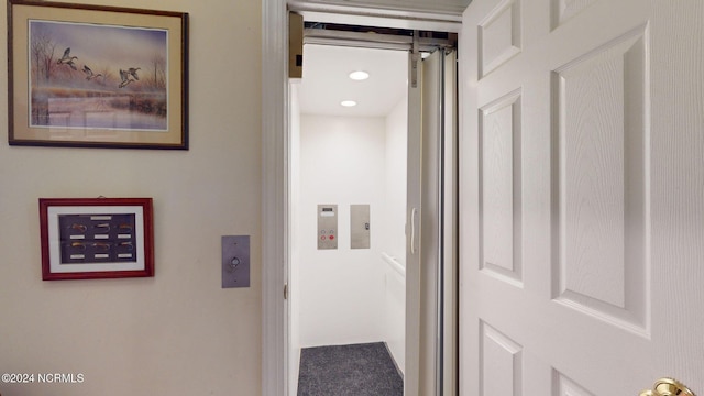 hallway with carpet and elevator