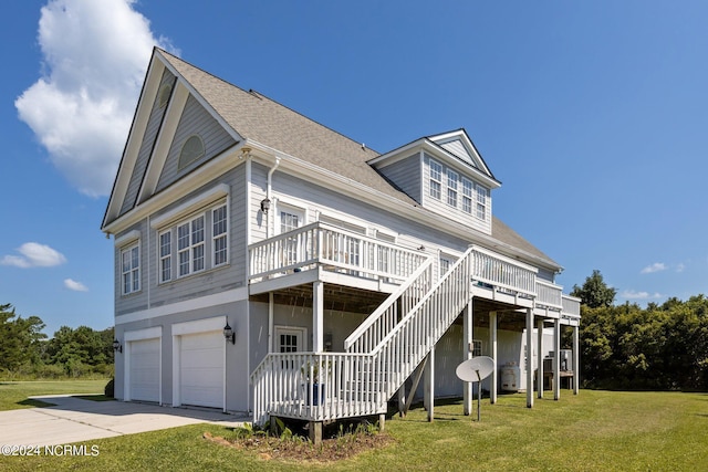 view of front facade with a deck, an attached garage, concrete driveway, stairway, and a front lawn