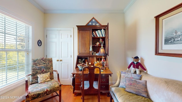 living area with wood-type flooring and ornamental molding