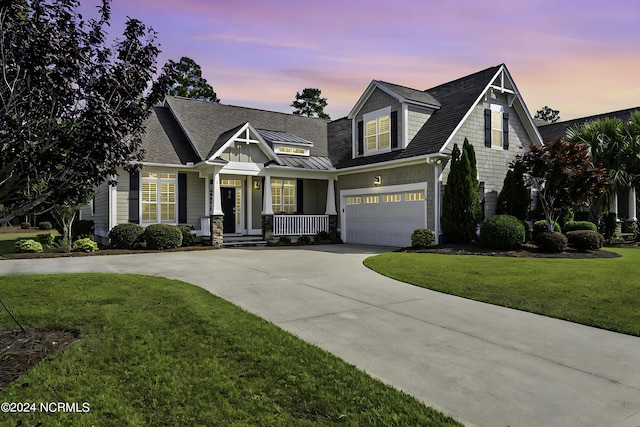 view of front of house with a shingled roof, concrete driveway, an attached garage, a standing seam roof, and a front yard