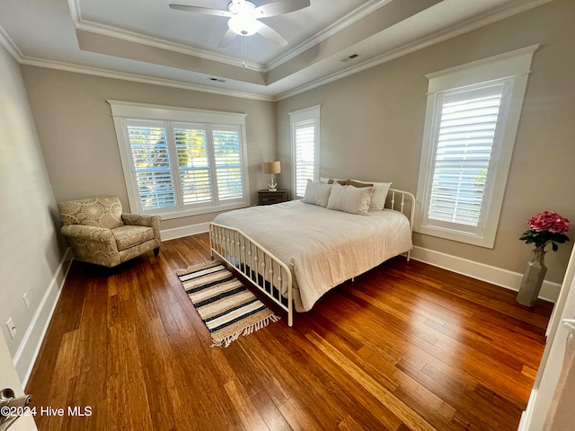 bedroom featuring ornamental molding, a raised ceiling, and hardwood / wood-style floors