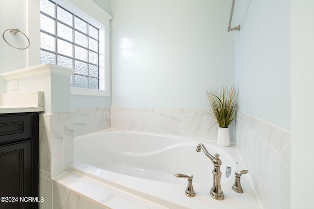 bathroom with vanity and a bath