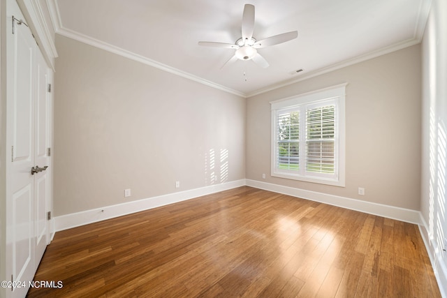 spare room with baseboards, ceiling fan, wood-type flooring, and crown molding