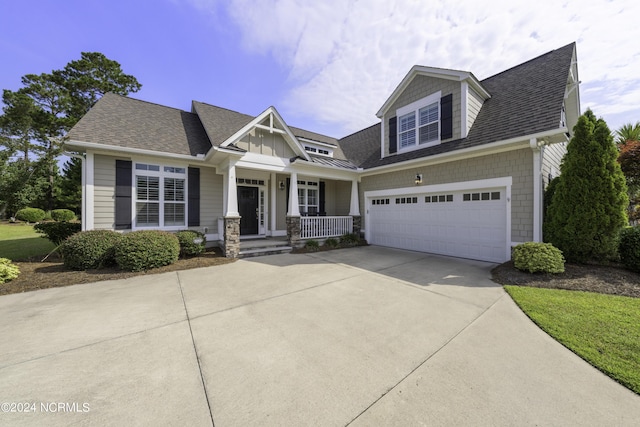 view of front of home featuring a garage, driveway, and a shingled roof