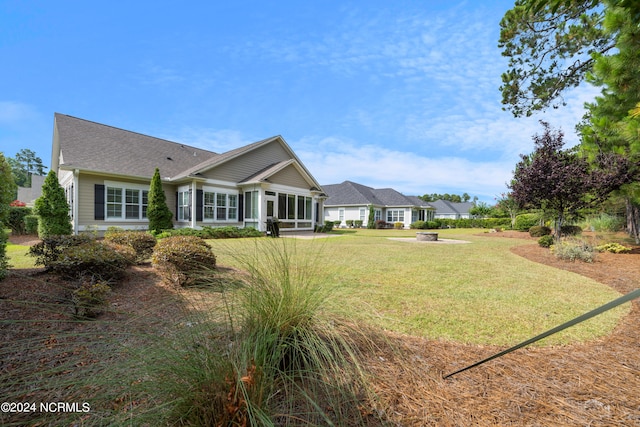 rear view of house with a sunroom and a lawn