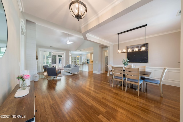 dining space featuring lofted ceiling, hardwood / wood-style flooring, ornamental molding, and ceiling fan with notable chandelier