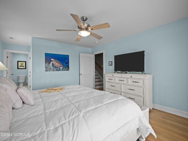 bedroom with ceiling fan, ensuite bathroom, and light hardwood / wood-style floors