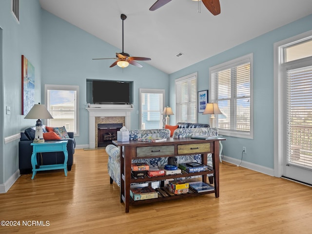 living room with ceiling fan, lofted ceiling, and light hardwood / wood-style flooring