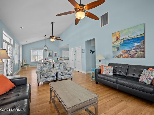 living room featuring ceiling fan, high vaulted ceiling, and light hardwood / wood-style flooring