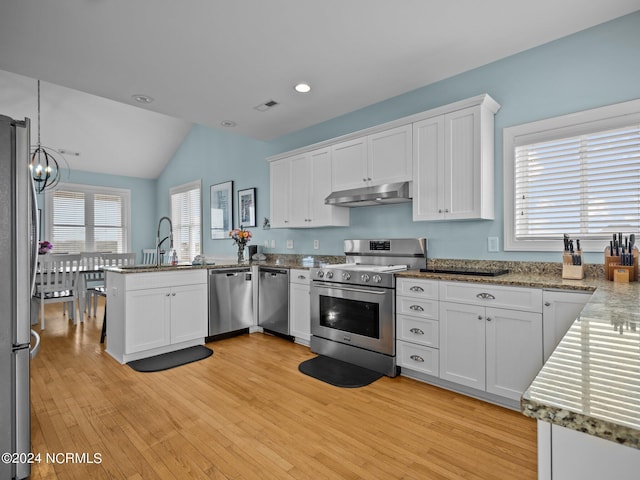 kitchen with appliances with stainless steel finishes, kitchen peninsula, sink, and white cabinets