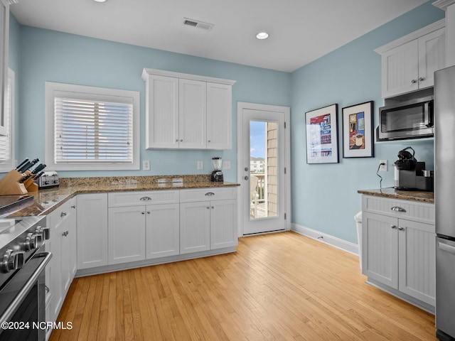 kitchen featuring white cabinetry, a healthy amount of sunlight, appliances with stainless steel finishes, and light wood-type flooring