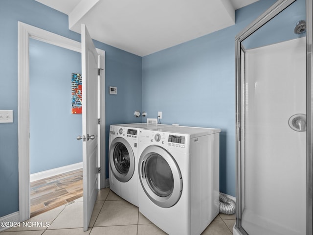 washroom featuring light tile patterned flooring and washing machine and clothes dryer