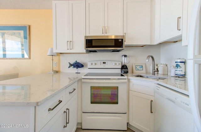 kitchen featuring white cabinetry, white appliances, light stone countertops, and sink