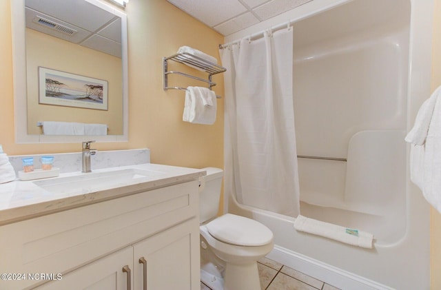 full bathroom featuring toilet, vanity, shower / bathtub combination with curtain, tile patterned flooring, and a drop ceiling