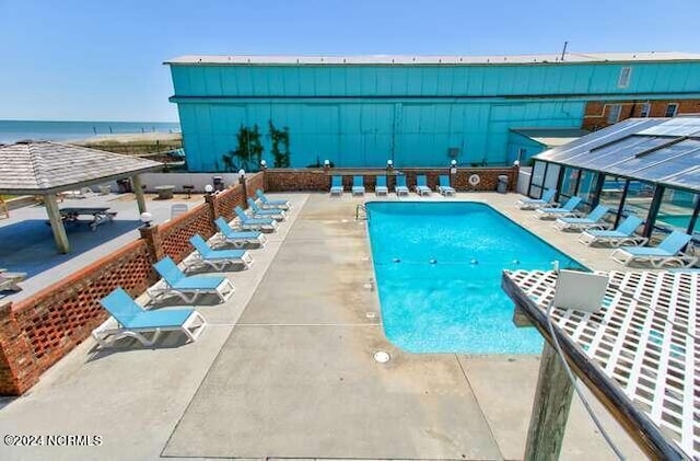 view of swimming pool featuring a gazebo, a patio area, and a water view