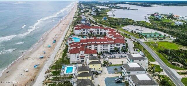 birds eye view of property with a water view and a view of the beach