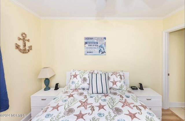 bedroom featuring crown molding and light hardwood / wood-style flooring