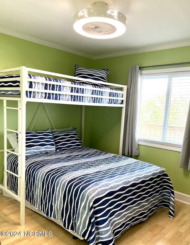 bedroom featuring ornamental molding and hardwood / wood-style floors