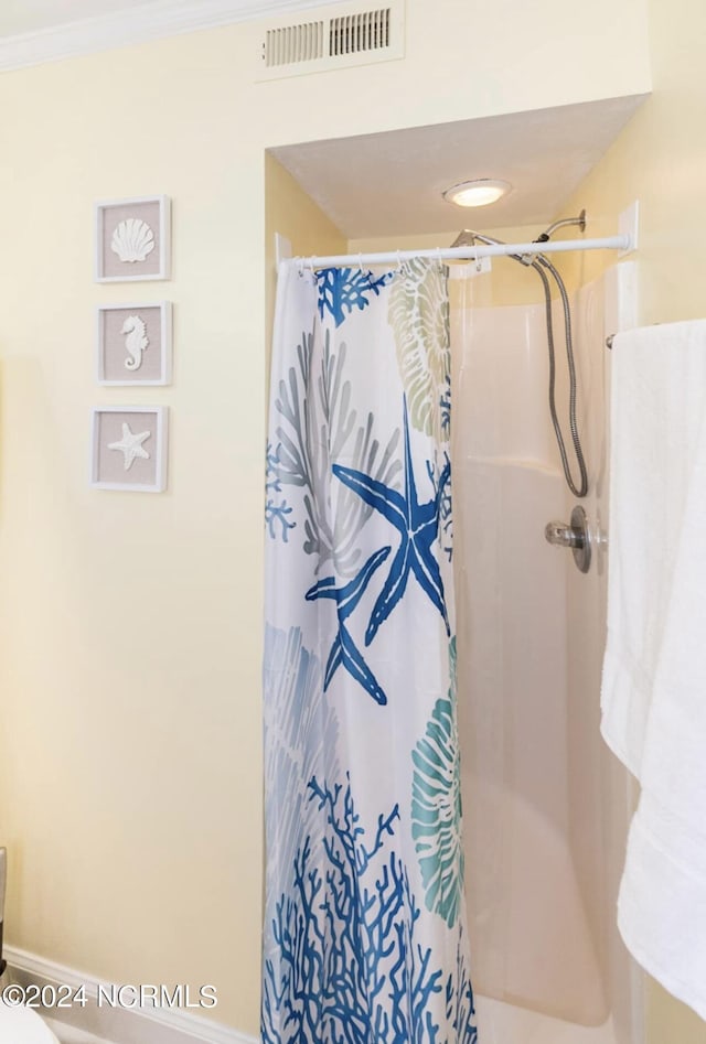 bathroom featuring crown molding and a shower with curtain