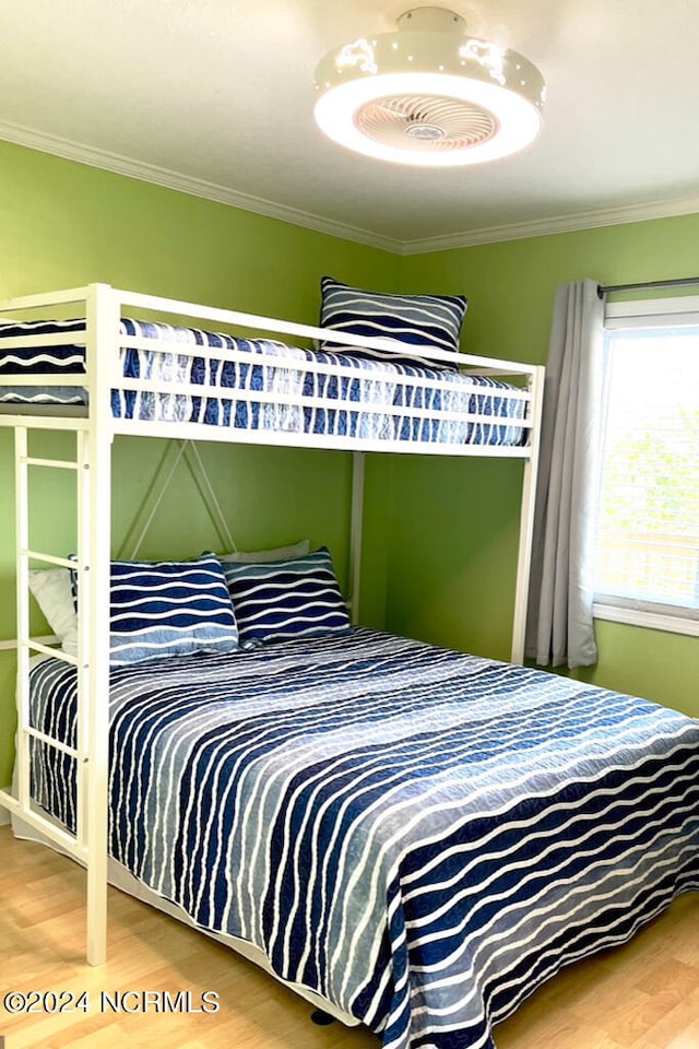 bedroom with hardwood / wood-style flooring and ornamental molding