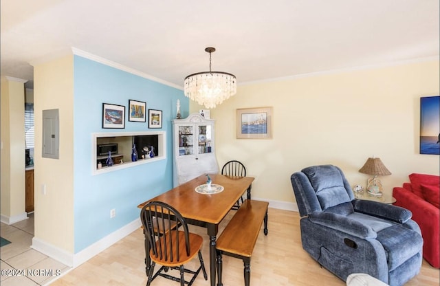 dining room featuring a chandelier, ornamental molding, electric panel, and light hardwood / wood-style floors