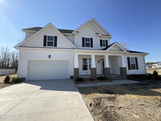 craftsman inspired home featuring a garage and a front lawn