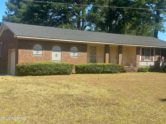 ranch-style house with a garage, a front yard, and covered porch