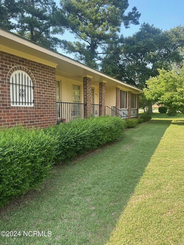 view of side of home with a lawn