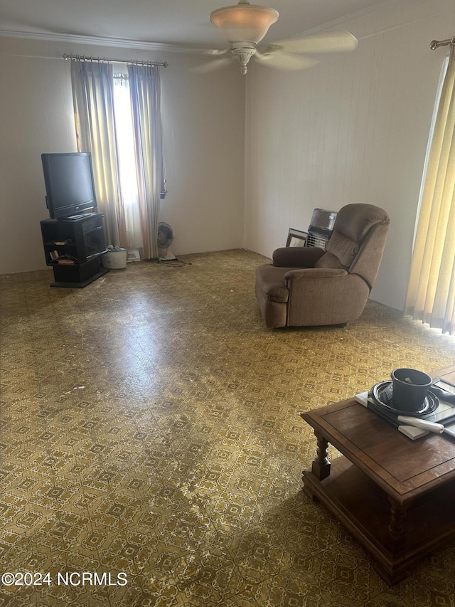 unfurnished living room with crown molding and ceiling fan