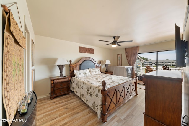 bedroom with access to exterior, a baseboard heating unit, light wood-style floors, and ceiling fan