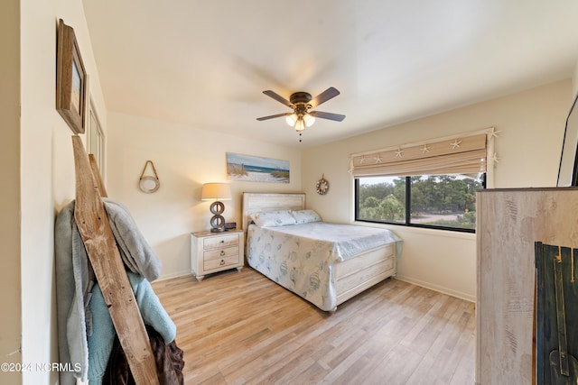 bedroom with a ceiling fan, baseboards, and wood finished floors