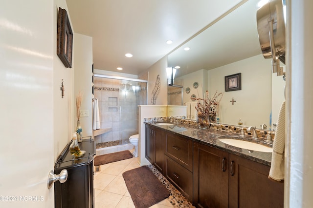 bathroom with toilet, a stall shower, tile patterned flooring, and a sink