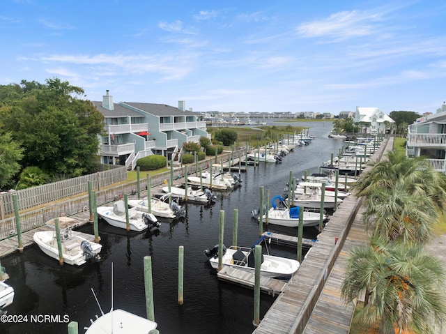 view of dock with a water view and fence