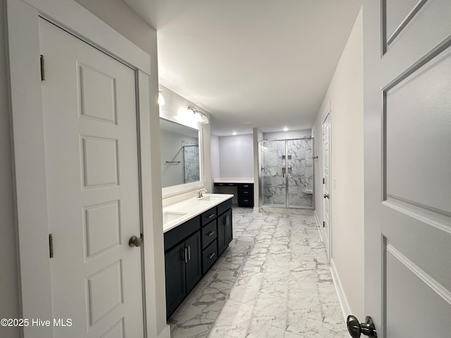 bathroom featuring a shower with door and vanity