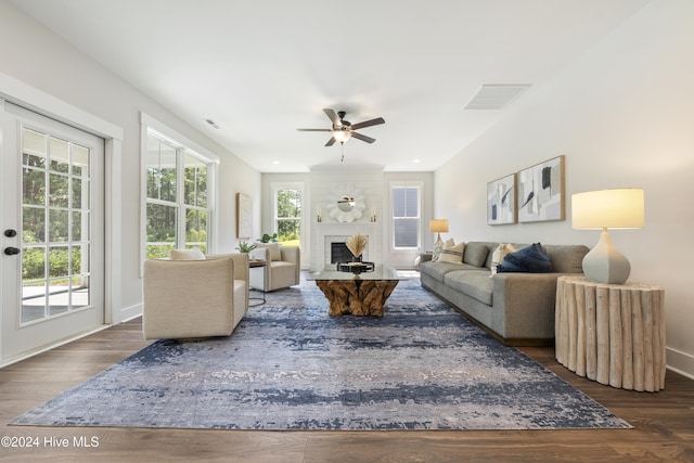 living room featuring a fireplace, ceiling fan, and dark hardwood / wood-style floors