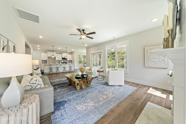 living room with ceiling fan and dark hardwood / wood-style floors