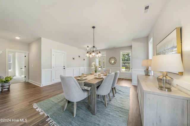 dining space with dark wood-type flooring and a chandelier